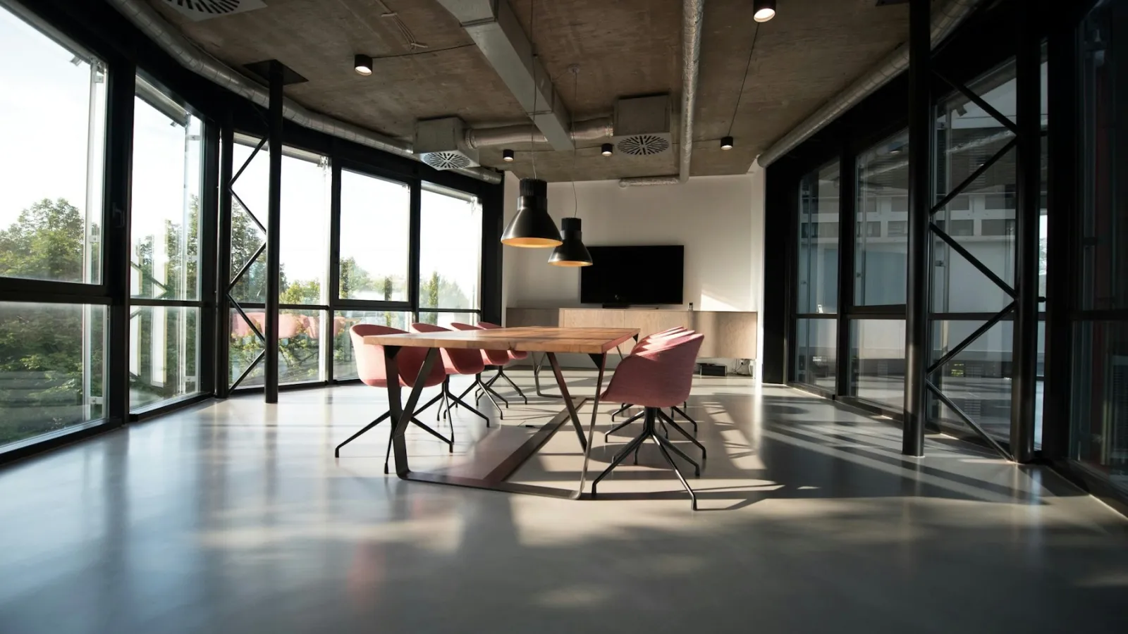 Sala de reunión con mesa de madera y luz natural