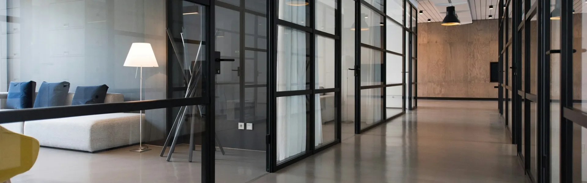 Pasillo de oficinas con salas de reunión acristaladas