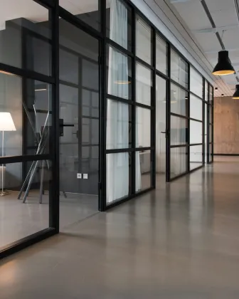 Pasillo de oficinas con salas de reunión acristaladas
